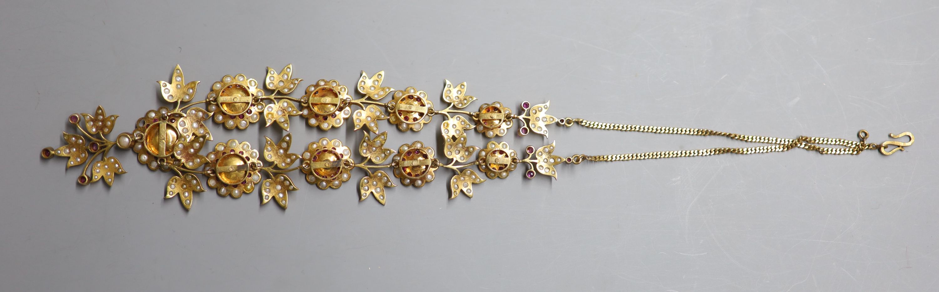 An early to mid 20th century Indian gilt metal, ruby and split pearl floral cluster drop necklace, approx. 50cm.